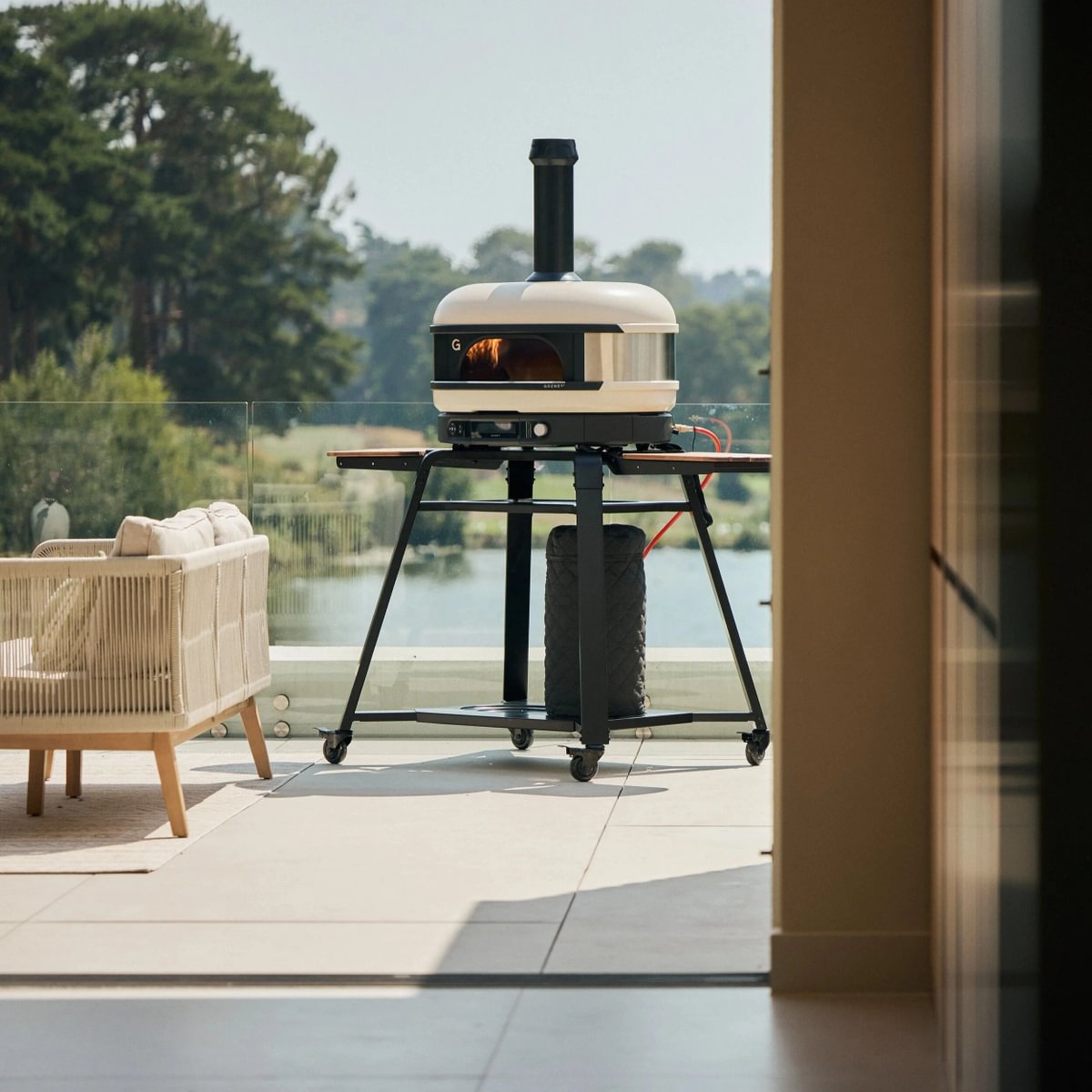 Gozney Pizzaofen Dome Gen 2.0 | Cremeweiß vor Pool mit Ständer